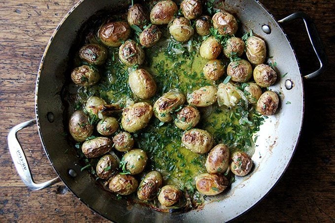 A braiser filled with roasted potatoes and tarragon.