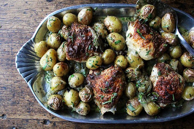 A platter filled with one-pan roast chicken and potatoes with tarragon.