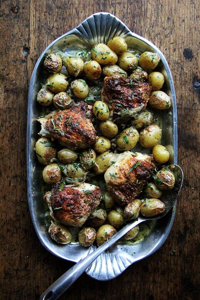 A platter filled with one-pan roasted chicken thighs and potatoes.