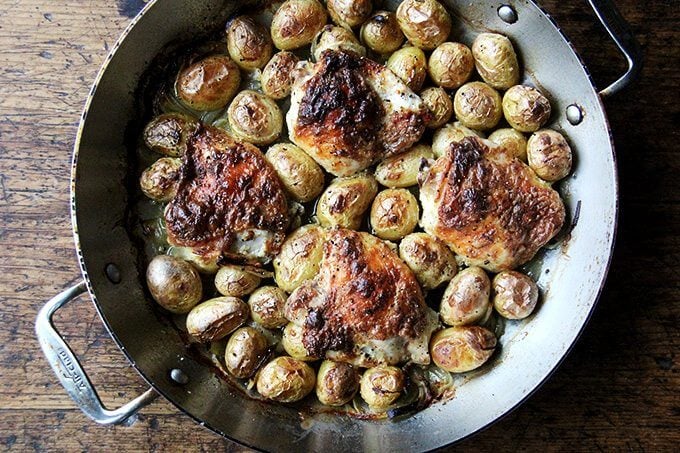 Just-cooked chicken and potatoes in braiser.