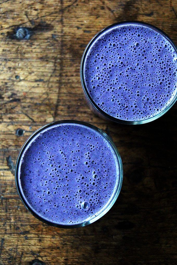 An overhead shot of two  blueberry-almond smoothies.