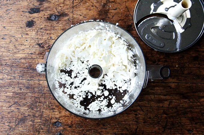 A food processor with shredded cauliflower. 