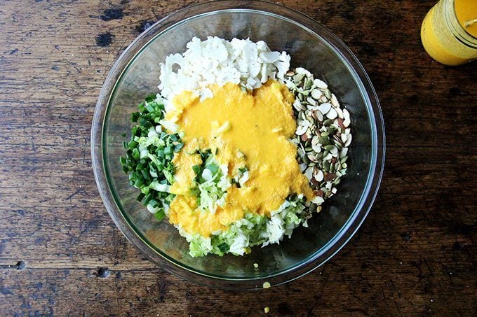 A bowl with all of the ingredients for the cabbage salad dressed in miso-carrot dressing. 