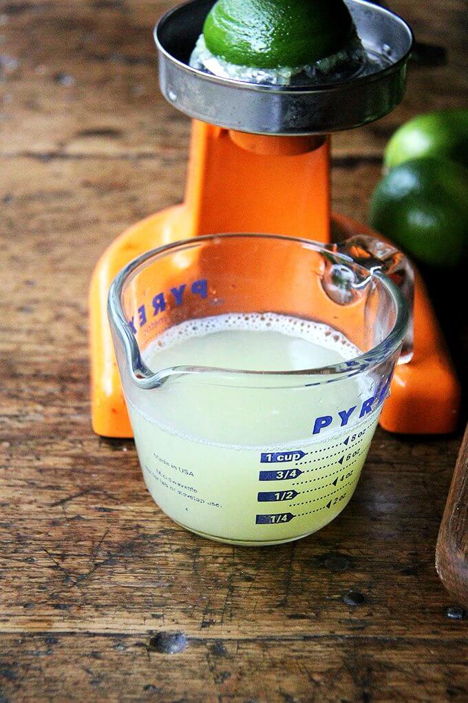 A cup of fresh-squeezed lime juice in a liquid measure. 