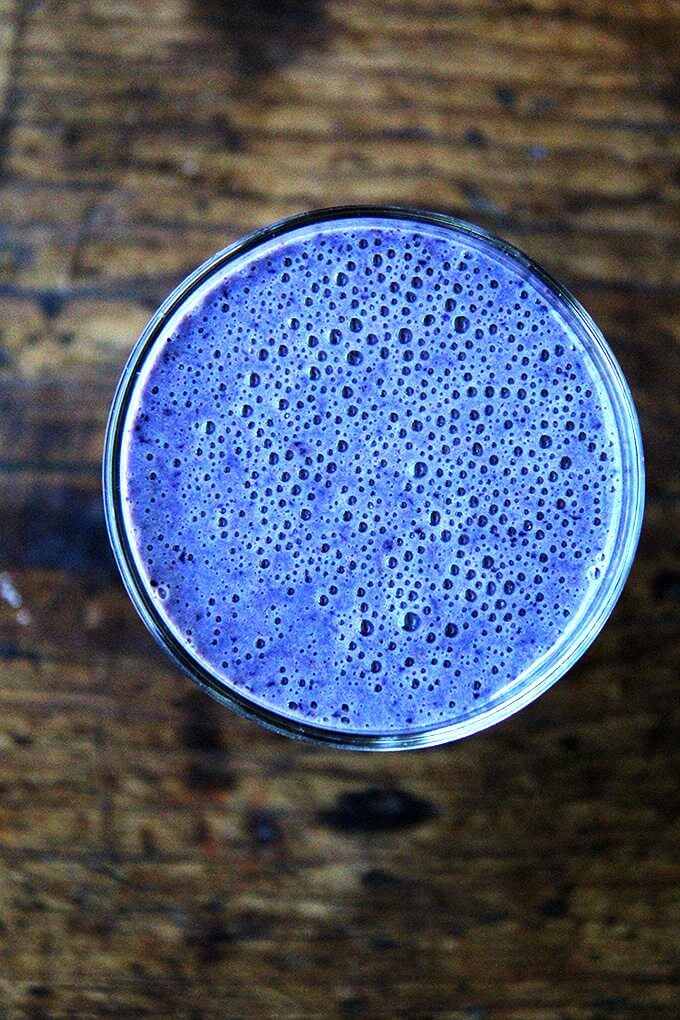 Overhead shot of a blueberry smoothie in a glass.