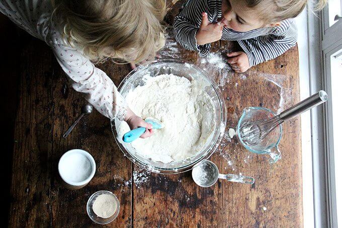 Overhead shot of kids making pizza dough. 