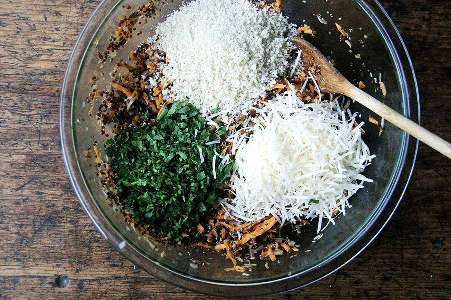 A bowl of grated sweet potatoes, herbs, bread crumbs, cheese, and mushrooms for veggie burgers.