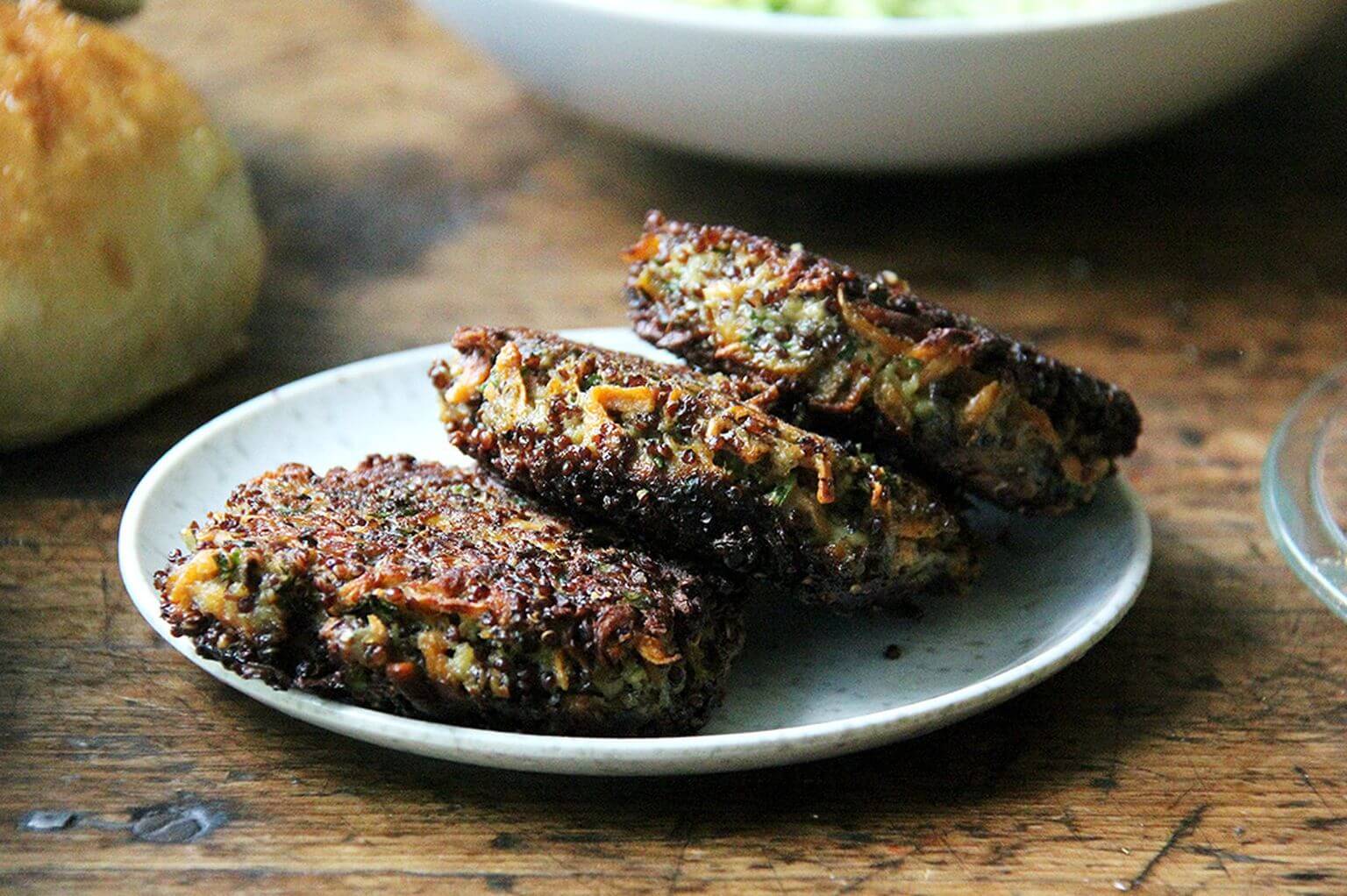 A plate of three crispy mushroom-quinoa burgers.