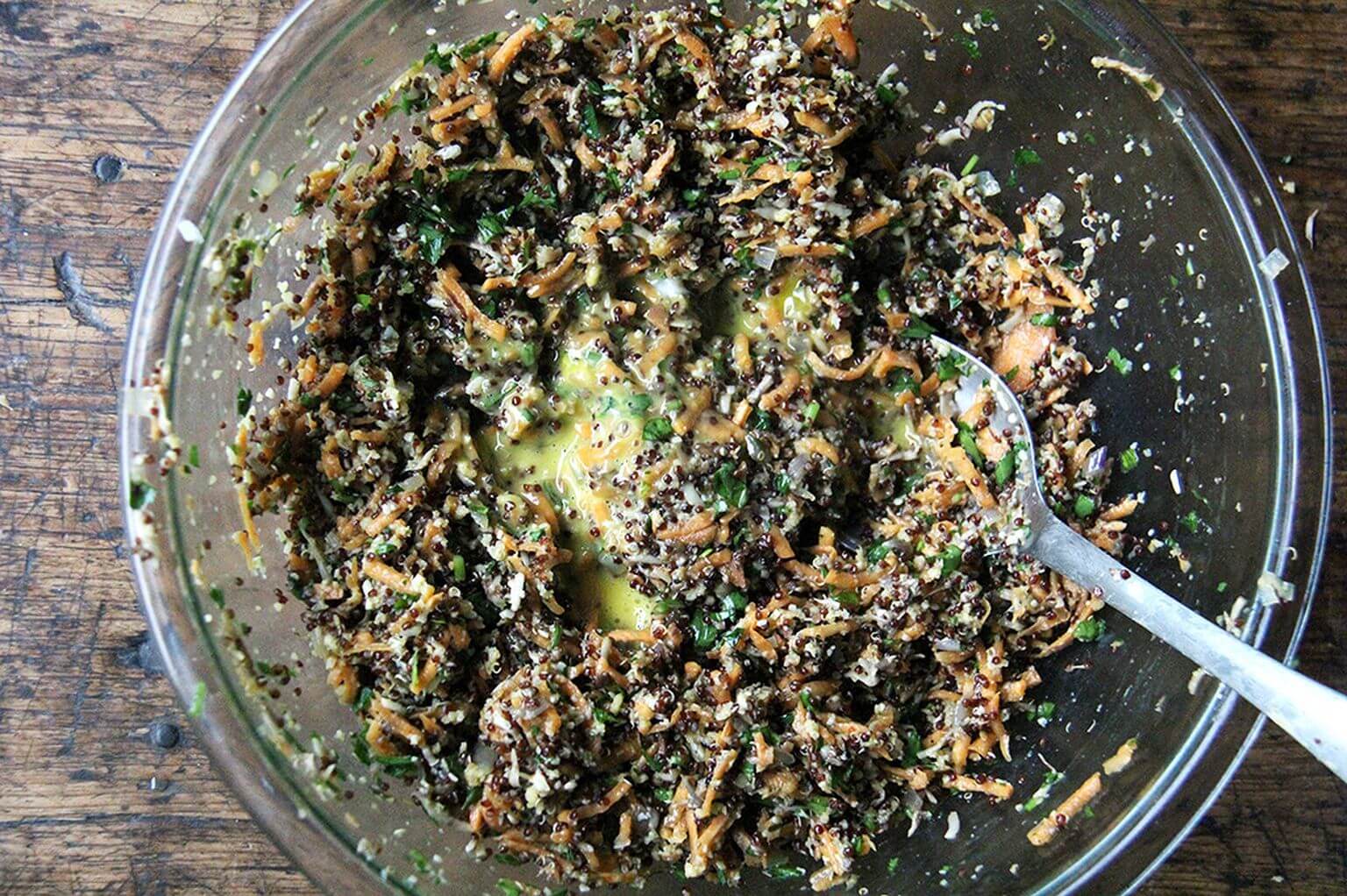 A bowl of grated sweet potatoes, herbs, eggs, bread crumbs, cheese, and mushrooms for veggie burgers.