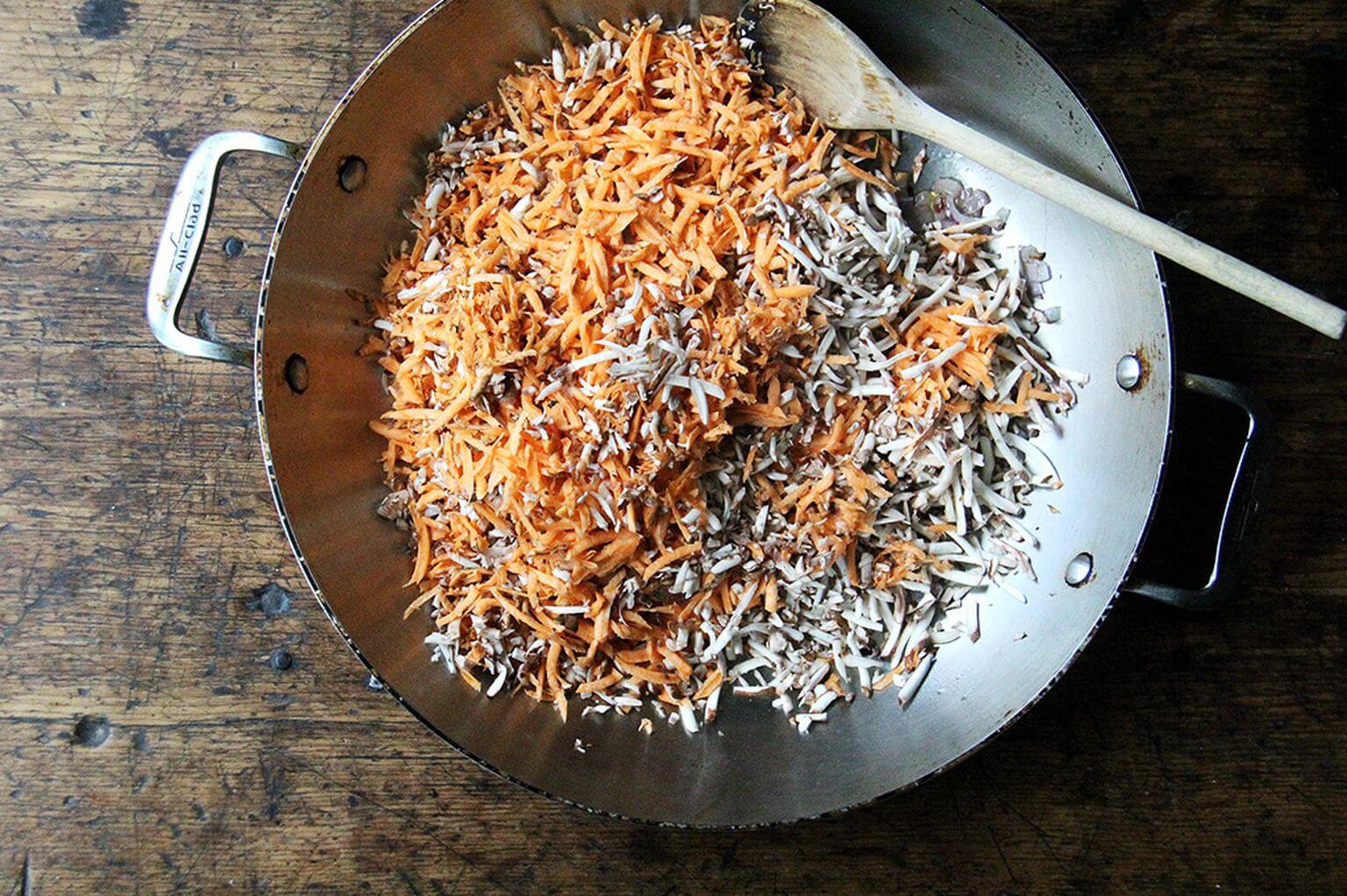 A skillet with sautéed sweet potato and mushrooms.