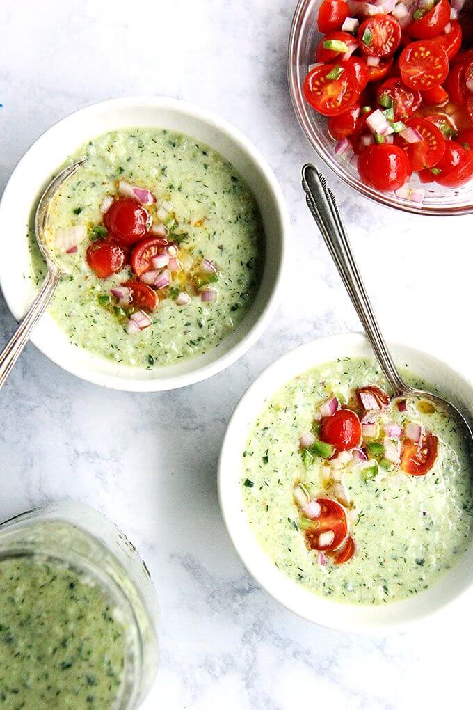 Two bowls of cucumber grape gazpacho with tomato salsa.