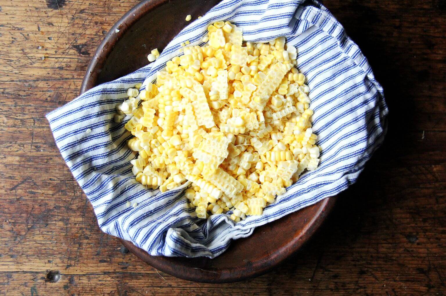 A bowl filled with stripped corn kernels.