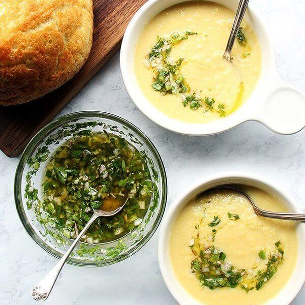 Overhead shot of corn soup with herb salsa.