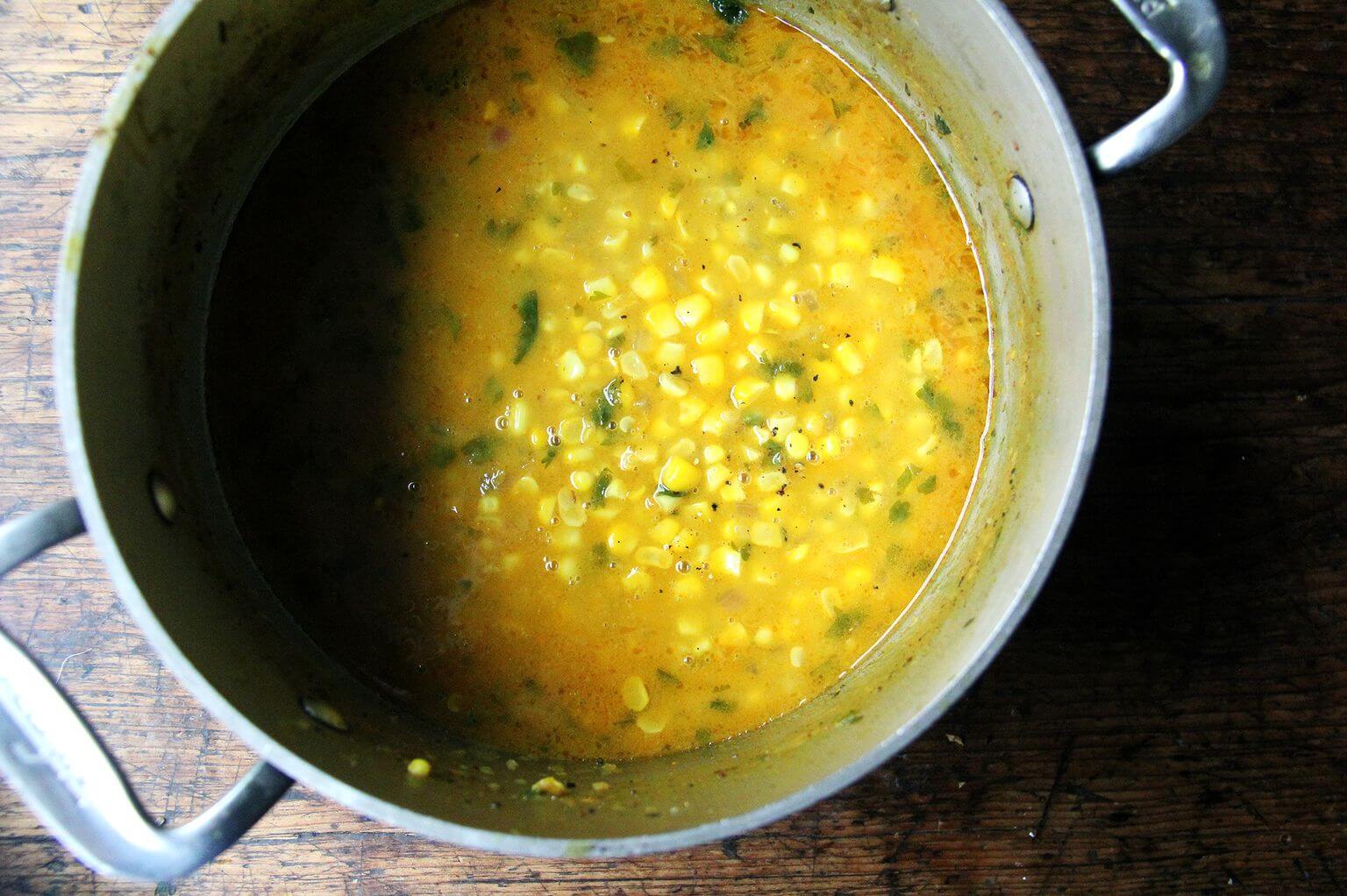 A pot filled with curried coconut corn soup.