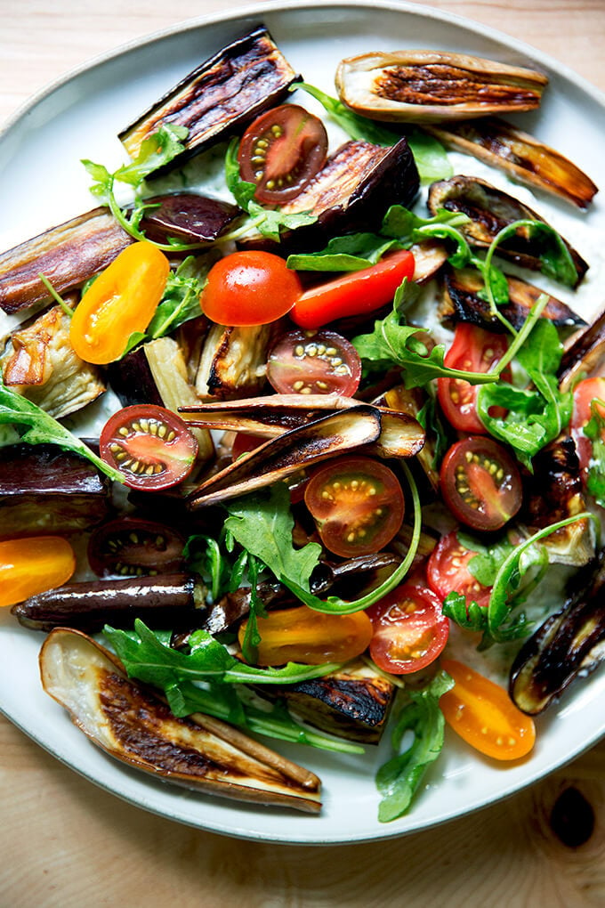 A plate of roasted eggplant salad with tzatziki and tomatoes. 