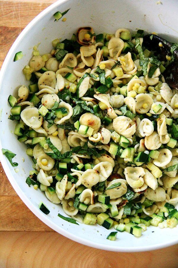 A bowl of toasted orecchiette pasta with corn and zucchini.