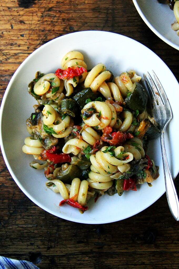 A plate of pasta tossed with roasted ratatouille. 