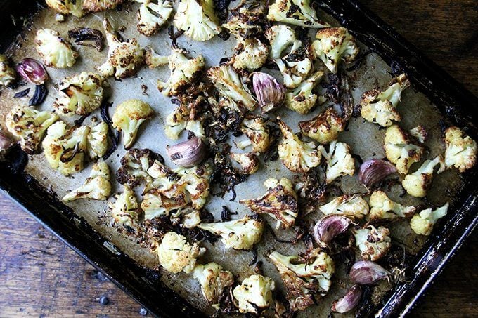 Oven-roasted cauliflower florets with parmesan and garlic on a sheet pan.