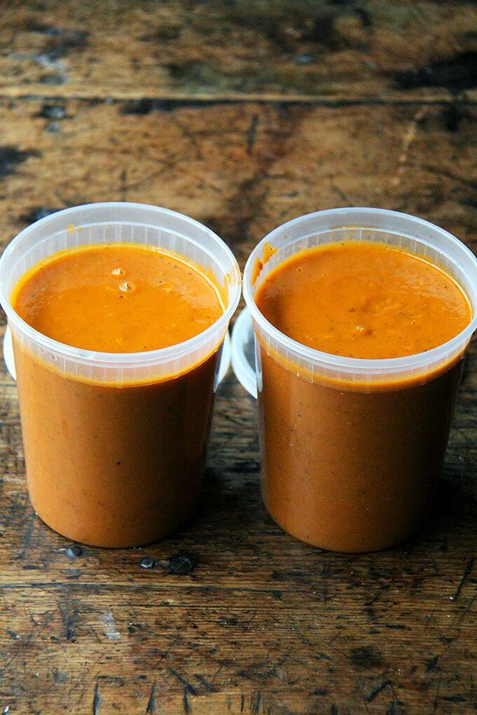 Two quart containers filled with tomato sauce.