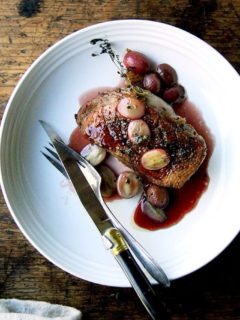 A plate of pan-seared Duck breasts with port wine sauce and roasted grapes.