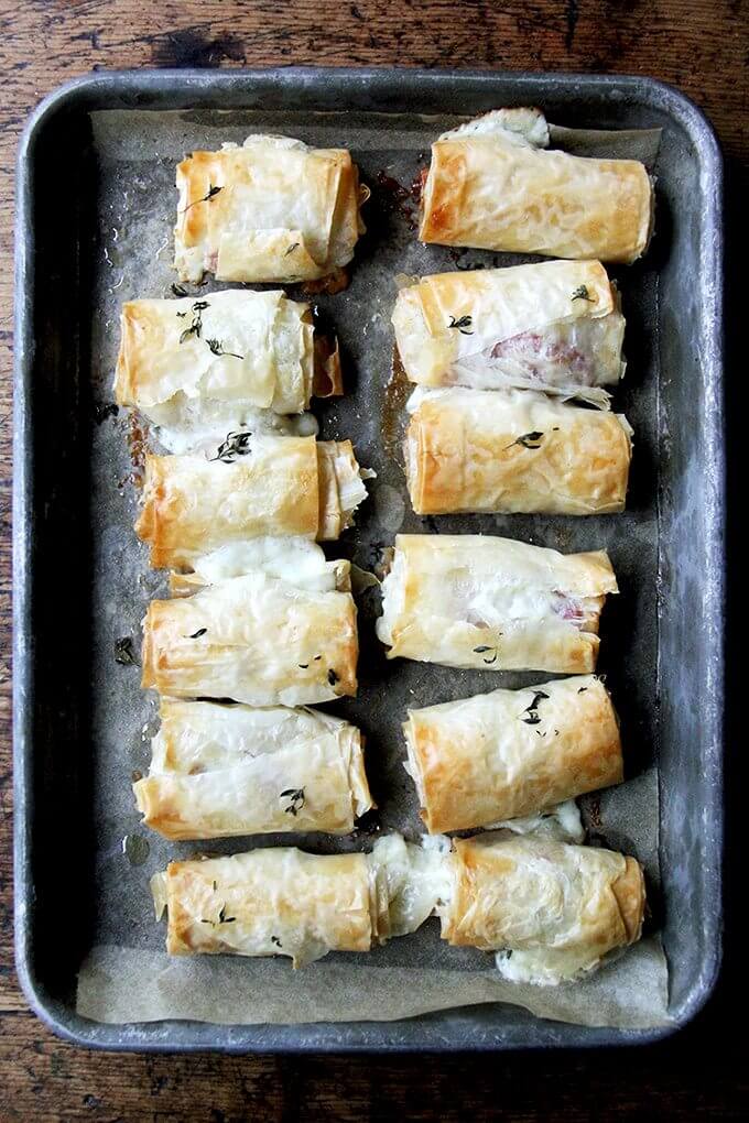 Just-baked salami and provolone phyllo rolls on a platter.