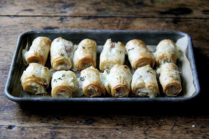 Just-baked salami and provolone phyllo rolls on a platter.