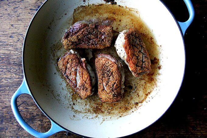 Four just cooked duck breasts in a Le Creuset braiser. 