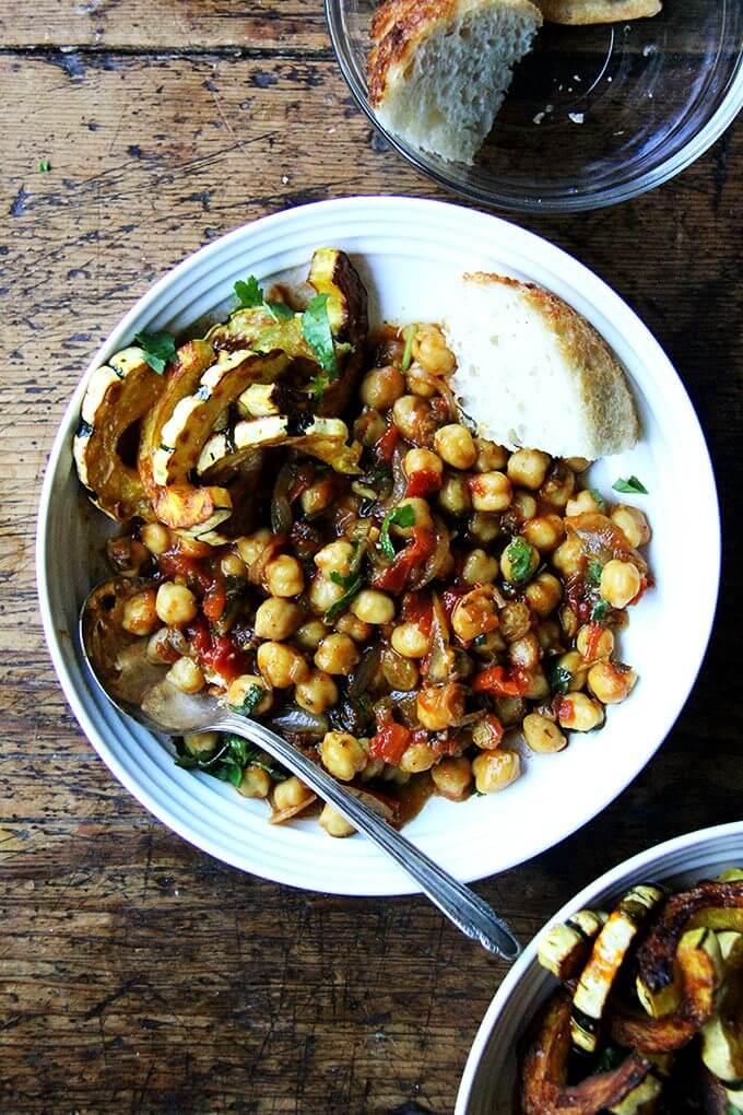 A bowl of chickpea tagine with tomato jam and roasted delicata squash.