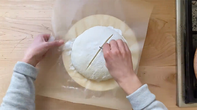 Scoring a loaf of sourdough bread. 
