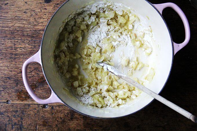 A large pot of onions sautéed in olive oil, with flour added. 