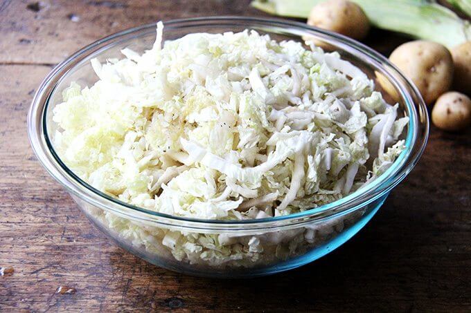 A large bowl filled with sliced cabbage. 
