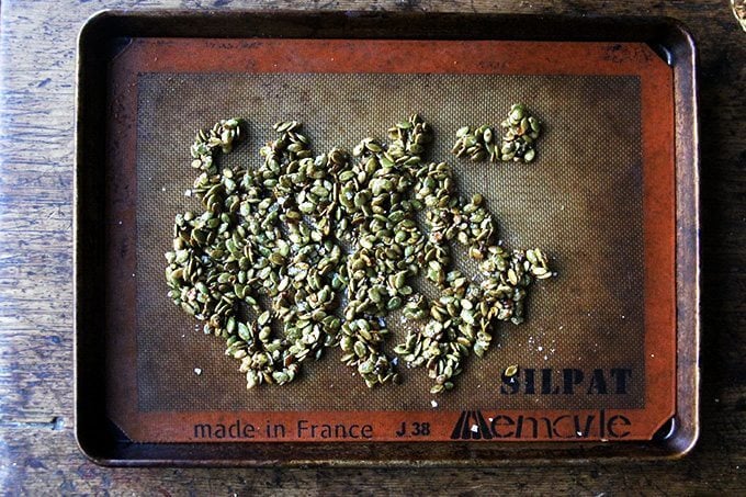 Candied pepitas on a Silpat-lined baking sheet.