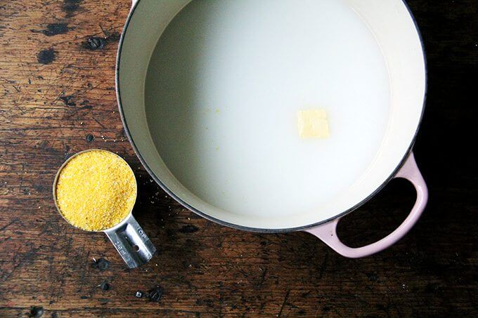 A Dutch oven filled with water, milk, and a pad of butter.