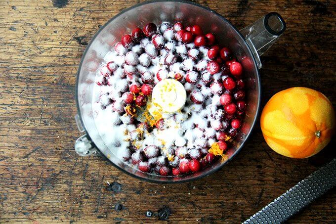 A food processor filled with cranberries, orange zest and sugar. 
