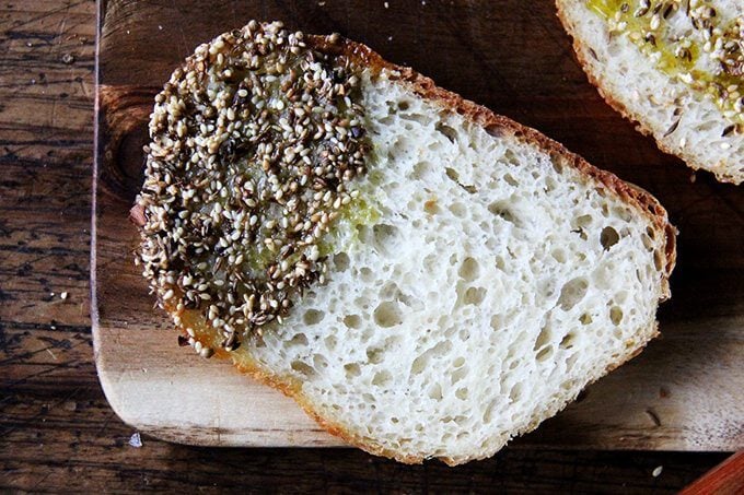 A board of sliced peasant bread dipped in olive oil and dukkah.