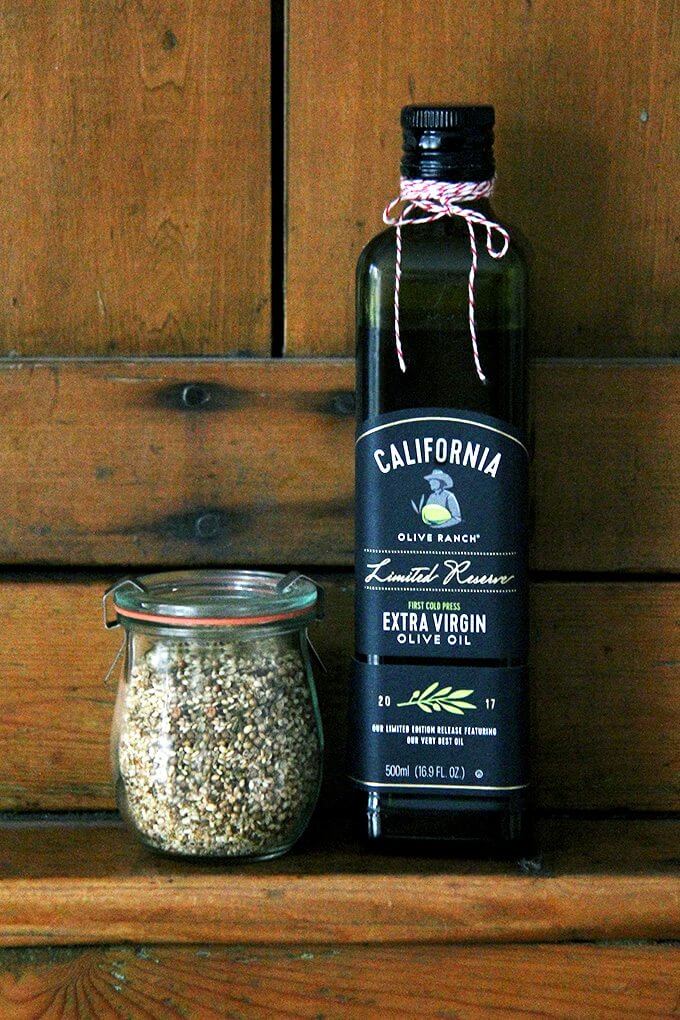 A bottle of California Olive Ranch olive oil aside a jar of homemade dukkah.