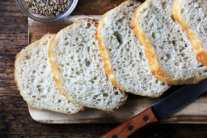 A board of sliced homemade peasant bread.