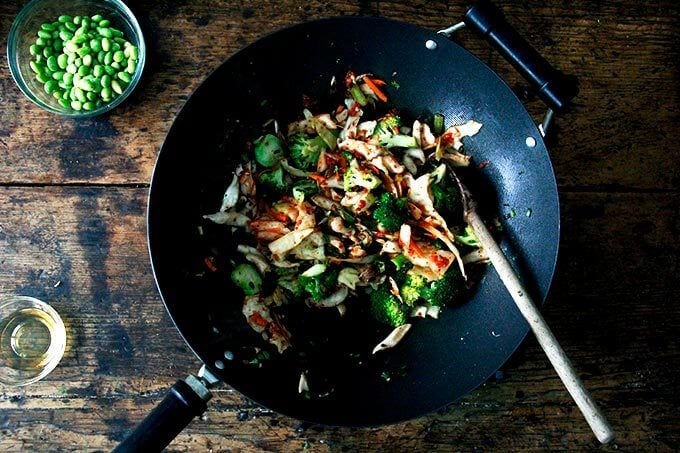 A wok filled with broccoli, shiitakes, and kimchi.