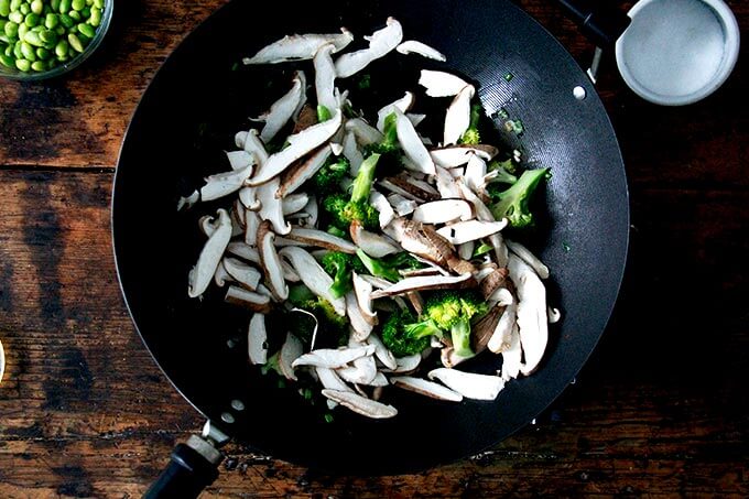 A wok filled with broccoli and shiitakes.