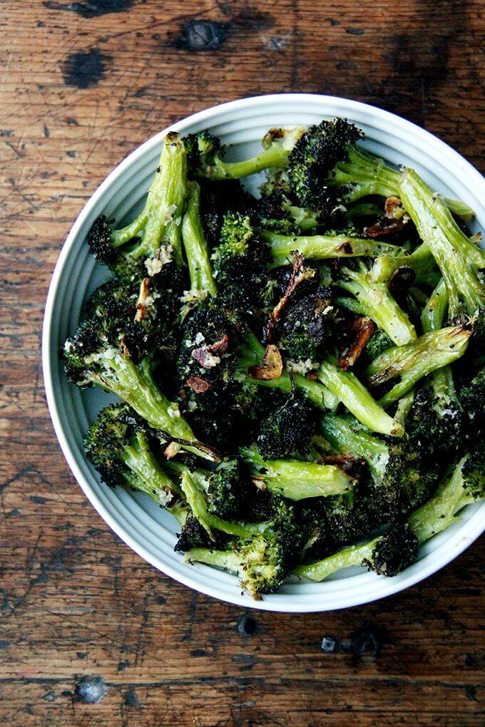 A bowl of roasted broccoli with lemon, garlic and parmesan.