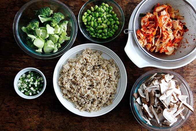 Ingredients prepped in bowls on a table for kimchi fried rice.