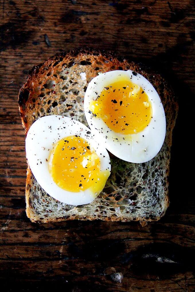 Loaf of quinoa-flax bread topped with soft-boiled eggs 