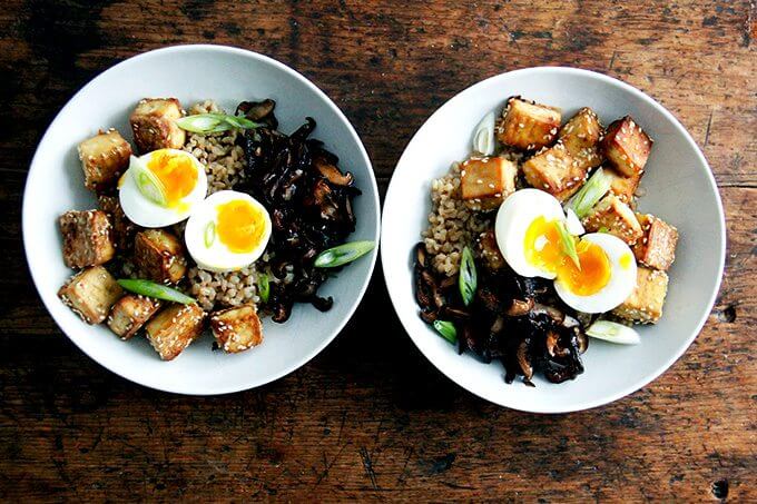 Two bowls of perfectly cooked Instant Pot brown rice topped with soft-boiled eggs. 