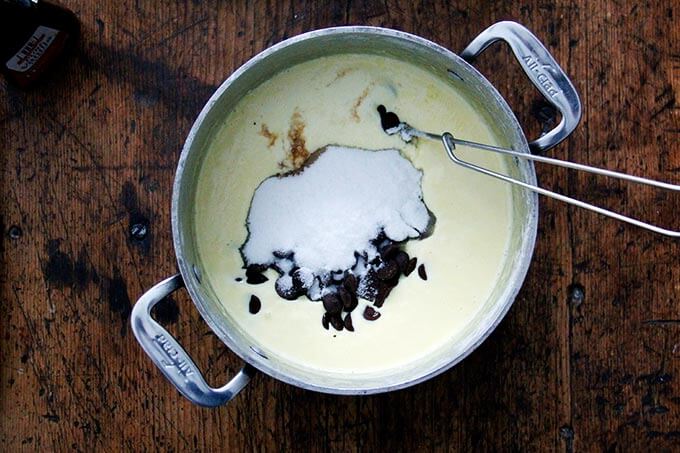 An overhead shot of a pot filled with an egg-cream custard, sugar, and chocolate. 
