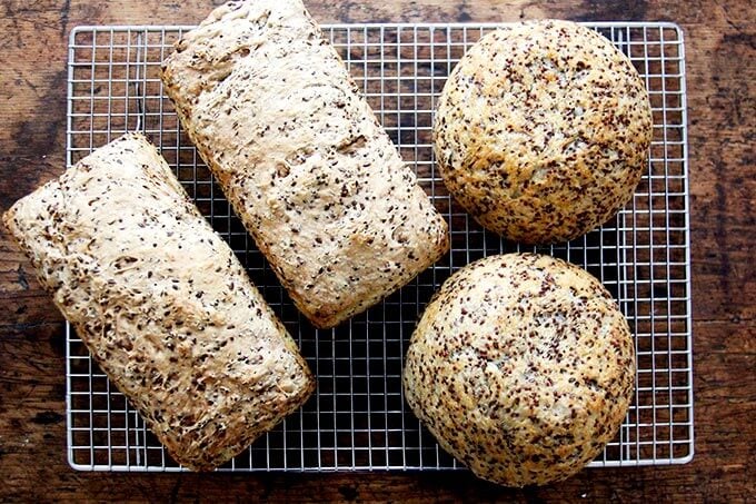 just-baked quinoa-flax pullman loaves and dinner loaves cooling on cooling rack.