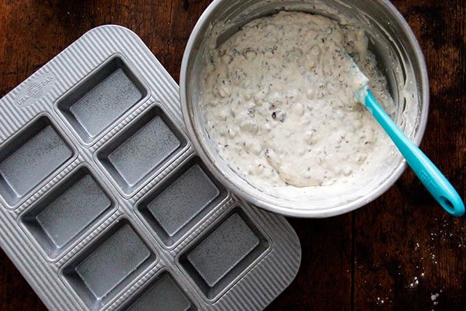 A greased 8-pan mini loaf pan aside batter for 3 seed crackers.