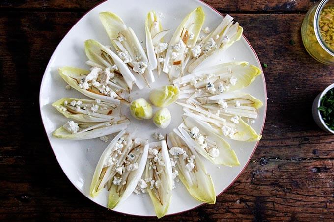 A platter of endive boats with slivered pears and blue cheese.