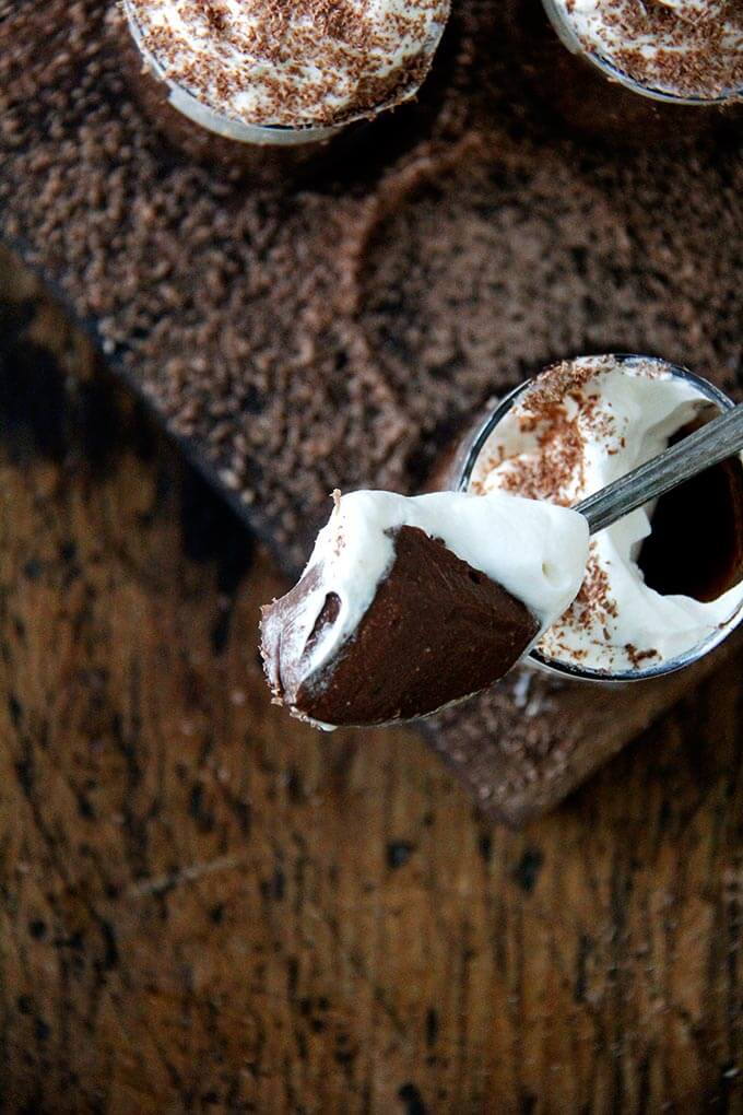 A spoonful of homemade stovetop chocolate pot de creme and whipped cream.