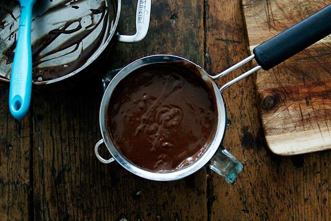 An overhead shot of a strainer set in a liquid measure filled with the chocolate pot de creme custard.