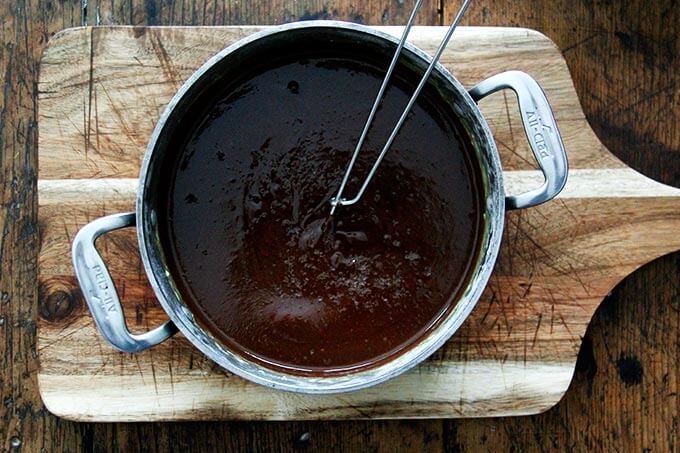 An overhead shot of a pot holding the pot de creme mixture with a whisk inside. 